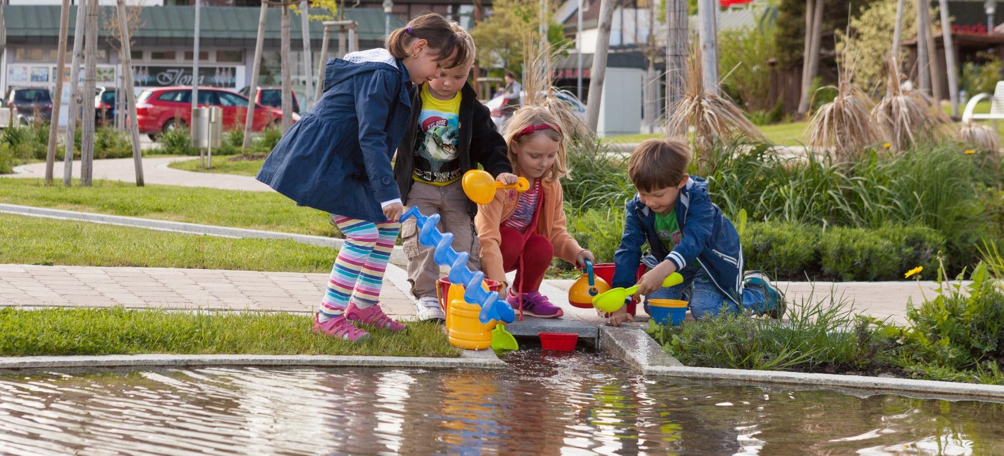 Spielende Kinder in der Ortsmitte am Wasserlauf Spielende Kinder in der Ortsmitte am Wasserlauf